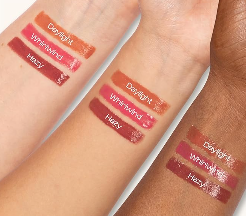 Lipstick swatches on three different skin tones with labels 'Daylight', 'Whirlwind', and 'Hazy'.