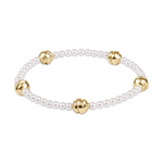 Stretch bracelet with white pearls and four gold beads