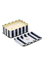 Paddywax Black Fig soy wax candle in a rectangular black and white striped tin container with two lit wicks and its matching lid showcasing a gold-rimmed label featuring a red tiger and moon logo