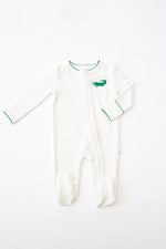 White long sleeve baby footie with green alligator embroidery and green scalloped trim