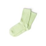 Pair of light green fuzzy crew socks on a white background