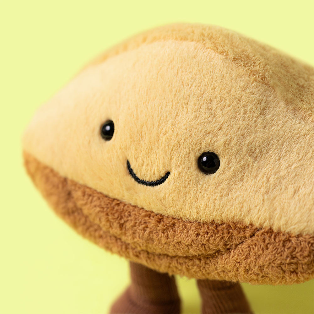 Tan and brown plush toy shaped like a mushroom with a smiling face