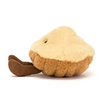 Plush toy shaped like a pie with a cream colored top and brown crust base with small dangling corduroy legs
