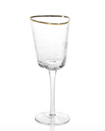 Clear hammered glass wine goblet with a gold rim