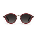 A pair of dark red round sunglasses featuring dark grey gradient lenses a silver metal bridge and decorative silver pins on the temples presented on a clean white studio background