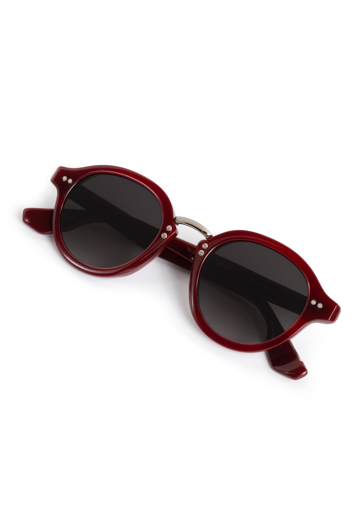AHTON sunglasses a pair of dark oxblood red frames with dark tinted lenses small silver stud accents and a "New Orleans" inscription shown on a clean white background