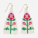 Handcrafted seed bead dangle earrings with gold-toned ear hooks featuring a white fringe design, a central fuchsia and red flower with a gold center, green stems, and smaller pink accent flowers