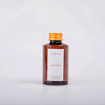 Amber glass bottle of Audubon diffuser oil with a gold cap