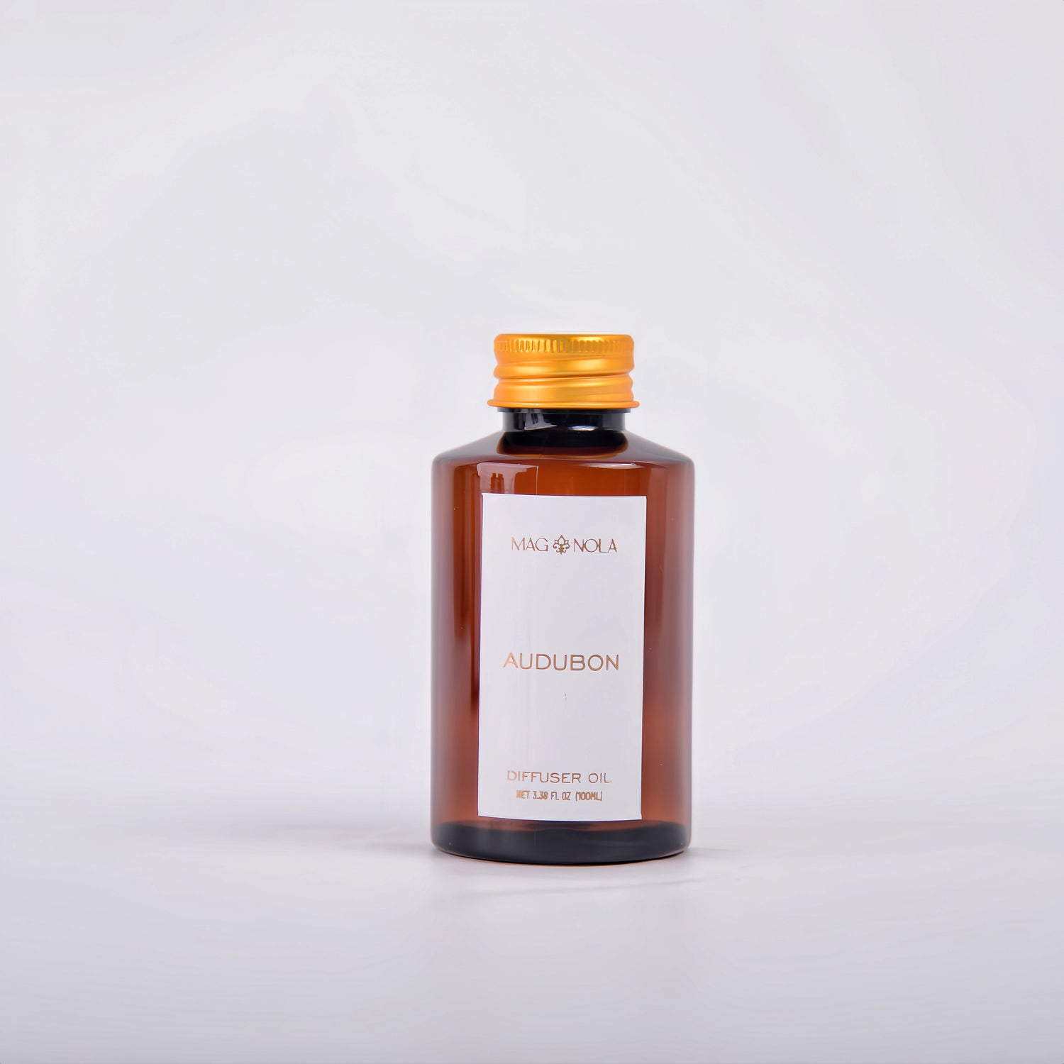 Amber glass bottle of Audubon diffuser oil with a gold cap