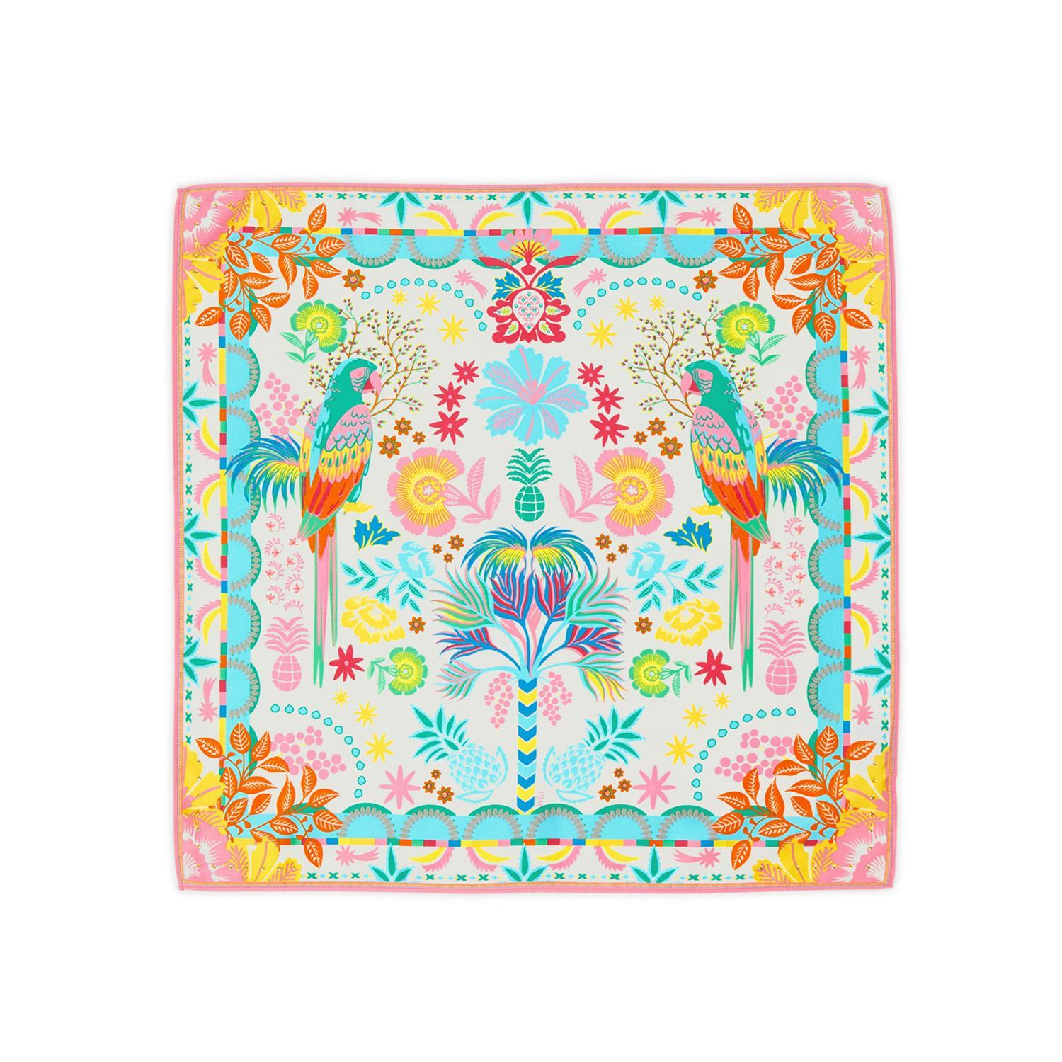 Textile design showcasing a symmetrical vibrant tropical pattern featuring two facing macaws, a central stylized palm tree, abundant pink and yellow flowers, and blue-green pineapples within a dynamic scalloped and geometric border