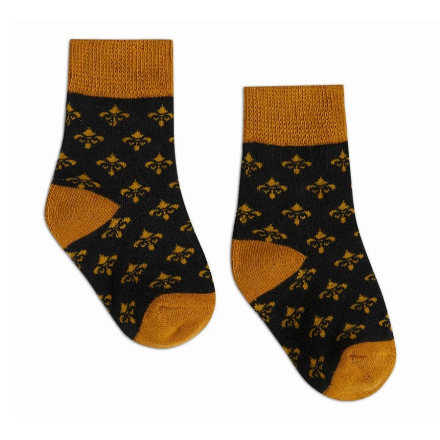 Textile pair of black socks featuring a repeating gold fleur-de-lis pattern with mustard yellow ribbed cuffs, heels, and toes