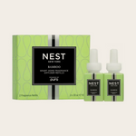 NEST New York Bamboo Smart Home Fragrance Diffuser Refills set featuring a vibrant lime green box with a subtle dotted pattern and a prominent black label, accompanied by two matching small light green refill bottles displaying 'NEST NEW YORK' and 'Powered by pura'