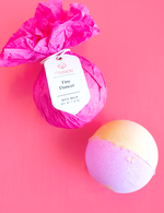Digital photograph by Musee featuring two vibrant bath balms on a hot pink background one wrapped in fuchsia tissue paper with a "Tiny Dancer" label and another unwrapped in pastel purple and pale yellow