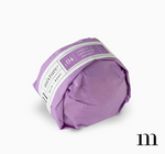 Purple wrapped bath bomb with a label reading Mixture Bath Body No 04 Laurens Lavender Garden