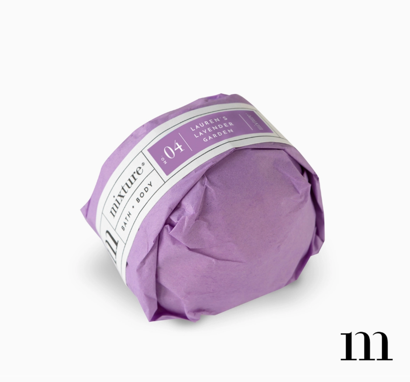 Purple wrapped bath bomb with a label reading Mixture Bath Body No 04 Laurens Lavender Garden