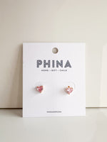 Pair of pink heart shaped stud earrings on a white branded display card