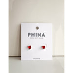 Red heart shaped stud earrings on a Phina branded display card