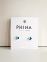 Blue heart shaped stud earrings on a Phina branded display card