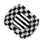 A glossy black and white geometric object featuring an irregular checkered outer shape framing a central striped oval