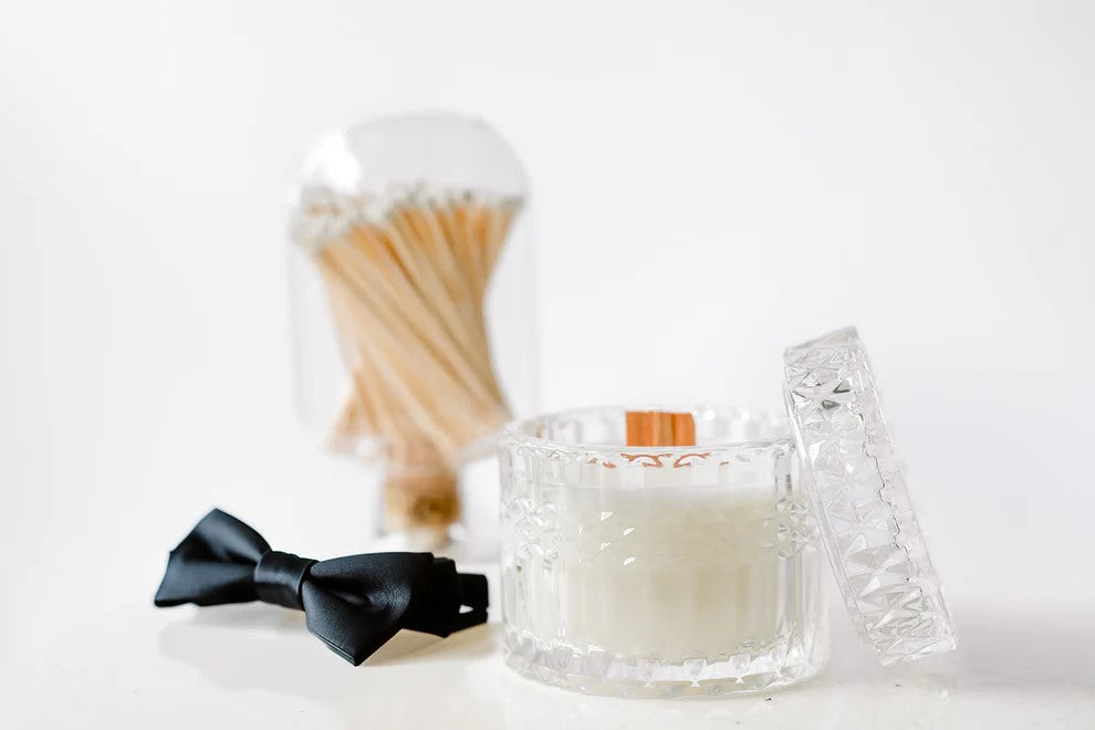 Crystal candle jar with lid, black bow tie, and glass cloche filled with matches