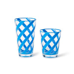 Hand-blown Murano glass drinking vessels are positioned on a white background, highlighting vibrant turquoise blue diagonal swirls and a unique crisscross latticework pattern across the clear transparent glass