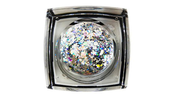 Digital photography of a clear square cosmetic pot holding a round insert of iridescent chunky silver and multicolored glitter flakes on a white background, displaying a dazzling array of particle sizes