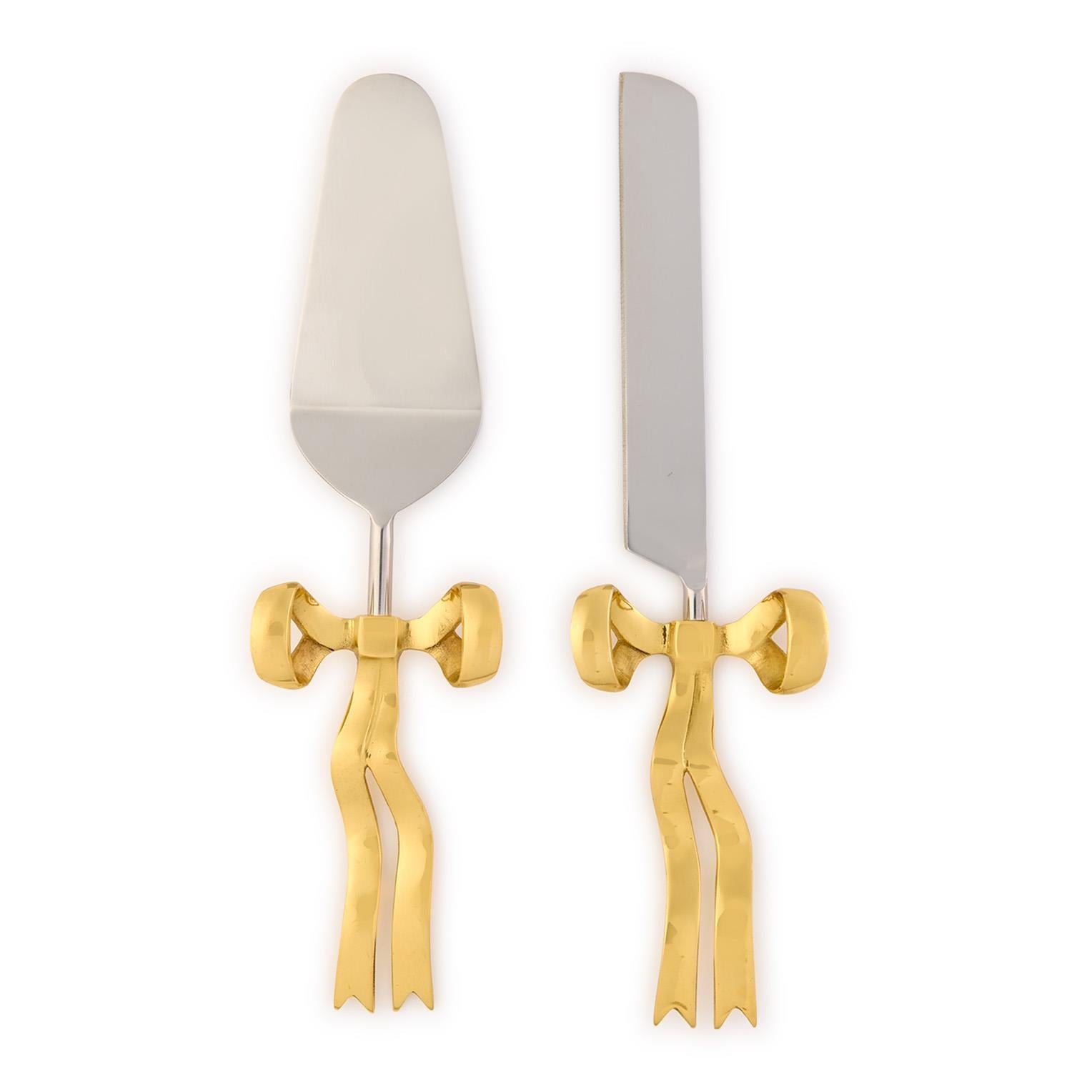 Photograph of an elegant silver cake server and knife set with shiny gold ribbon handles against a white background