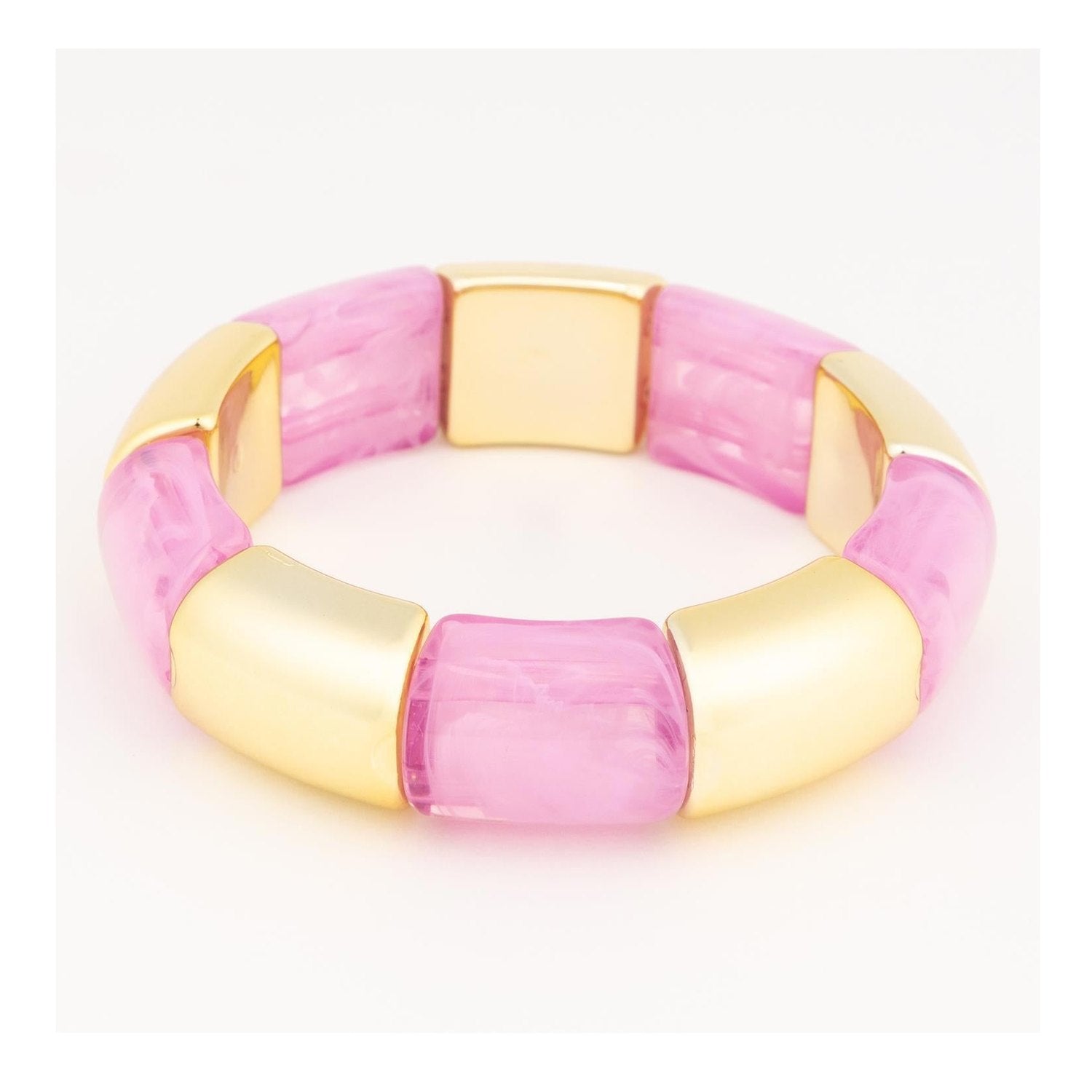 Resin and gold-toned metal stretch bracelet displayed on a white studio background featuring alternating square-shaped marbled pink tiles and smooth polished gold-finished segments