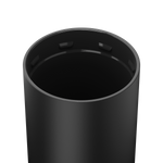 Matte black cylindrical container with a smooth dark interior and four rectangular slots visible just below its metallic rim against a white background