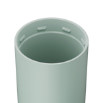 A light pastel green cylindrical container with a smooth matte finish, an open top revealing four small internal tabs evenly spaced around the inner rim
