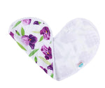 Muslin baby bib with a vivid purple iris and green leaf pattern on a white background, partially folded into a gentle curve