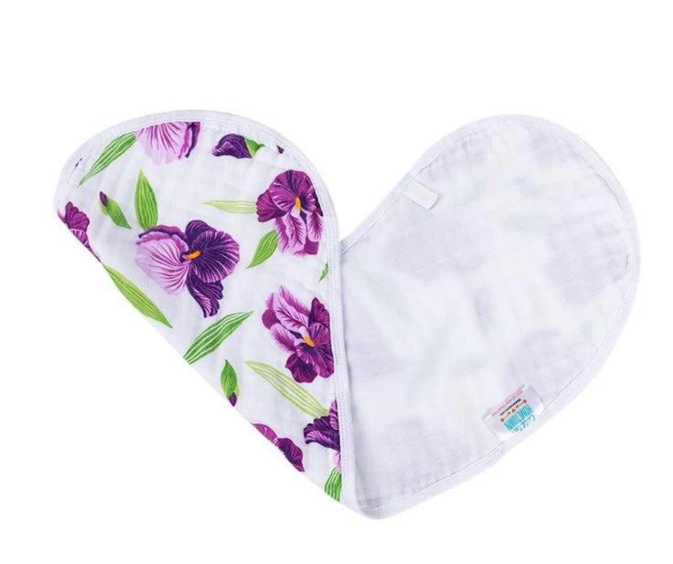 Muslin baby bib with a vivid purple iris and green leaf pattern on a white background, partially folded into a gentle curve