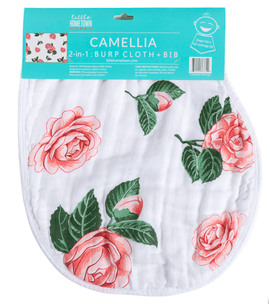Textile, Little Hometown Camellia design white 2-in-1 burp cloth and bib printed with vibrant coral pink camellia flowers and dark green leaves, topped by teal blue product packaging