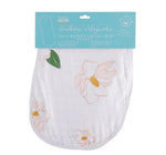 Product photography by Little Hometown of a white 2-in-1 burp cloth and bib from the Southern Magnolia collection adorned with soft pink magnolia flower illustrations, green leaves, and yellow centers on its fabric and product packaging