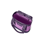 Product photography of an open YETI tote bag featuring a lilac exterior, deep purple interior, an internal zippered pocket, and dark gray webbing handles on a black background