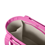 Digital photograph of a vivid pink tote bag in a studio shot revealing its structured light beige interior with multiple compartments and a vibrant pink zippered pocket