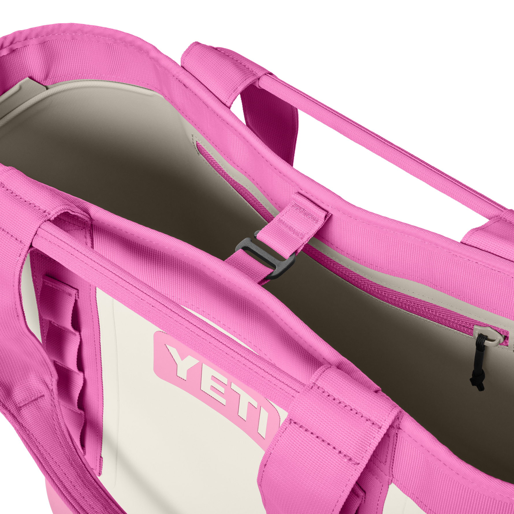 Close-up of a bright pink and off-white YETI Camino Carryall 35 bag, revealing its open top, the embossed pink YETI logo, an interior zippered pocket, and a central black buckle