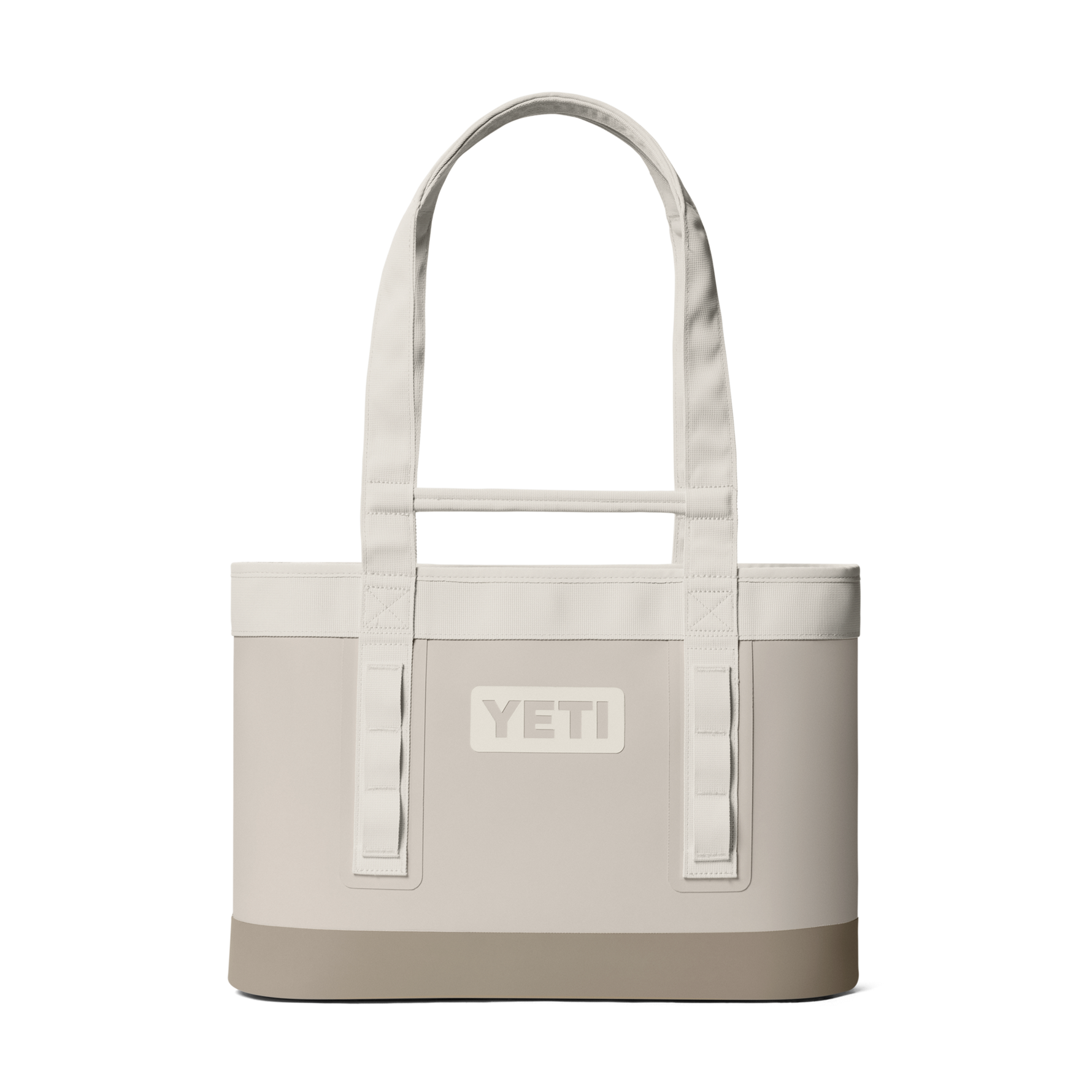 Product photograph of a Yeti Camino Carryall tote bag in cream featuring a reinforced tan base, an embossed central logo, and durable shoulder straps with integrated utility loops against a black background