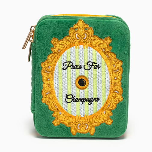 Green velvet zippered pouch with embroidered gold frame and Press For Champagne text