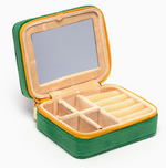 Green and yellow travel jewelry box open showing a mirror and beige velvet compartments with ring rolls