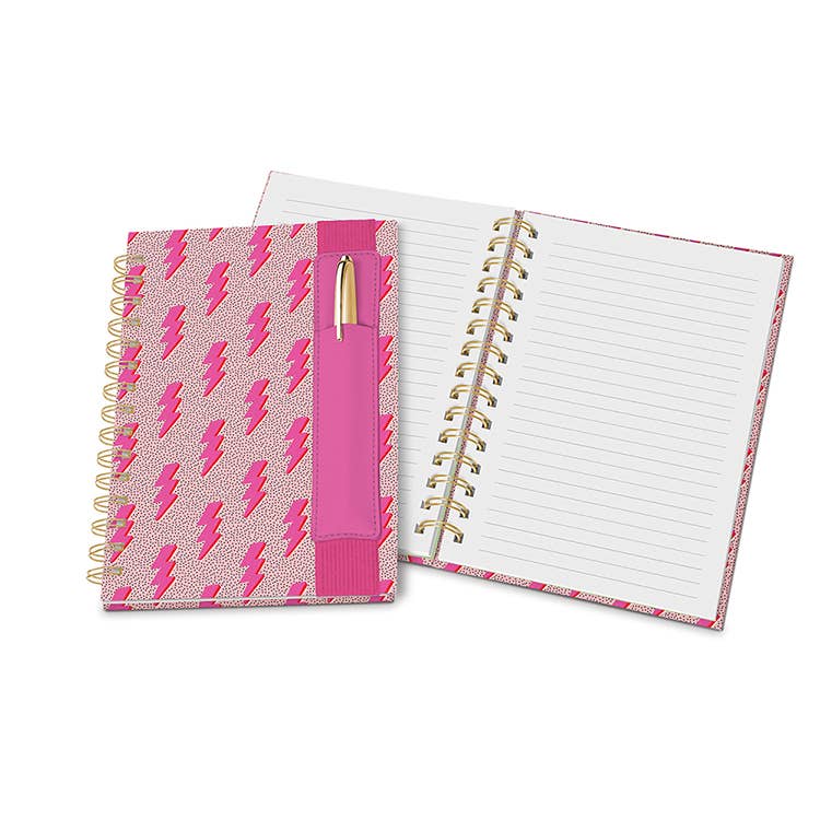 A vibrant pink lightning bolt patterned spiral-bound journal featuring a fuchsia pen holder with a gold pen, gold coils, and open lined pages