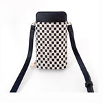 Woven leather cell phone crossbody bag on a clean white studio background displaying a striking black and white checkerboard weave, a textured black pebbled leather top flap, and elegant gold hardware accents