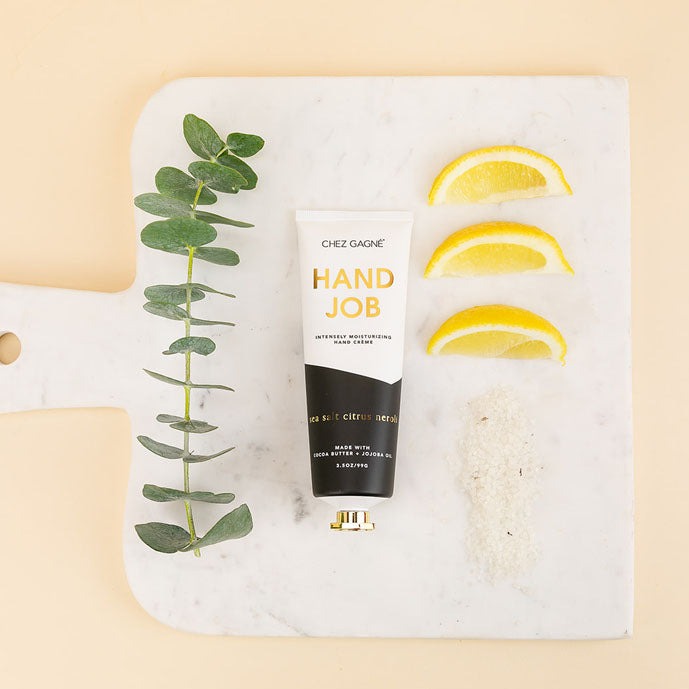 Hand creme tube with eucalyptus sprig lemon slices and sea salt on a marble board
