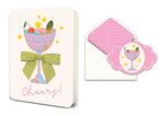 Greeting card with cocktail illustration and green ribbon next to matching envelope and sticker