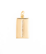 Gold jewelry pendant showcasing a rectangular charm centered on a white background with a vertical strip of pavé-set clear crystals and a polished yellow gold finish featuring a circular bail