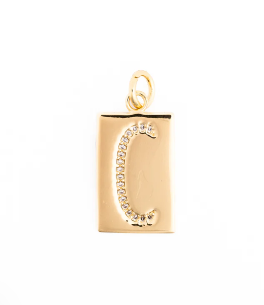 Gold jewelry pendant featuring a rectangular gold plate with a pave-set crystal letter C and a polished circular bail against a white studio background