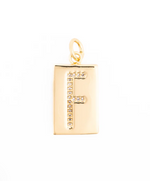 Gold jewelry pendant featuring a rectangular initial charm with a capital letter F encrusted in sparkling pavé stones and a polished gold finish on a white background