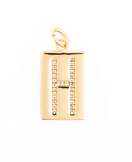 Gold rectangular pendant featuring a central pave-set letter H with shimmering white crystals on a polished metallic surface and a round top bail against a clean white background