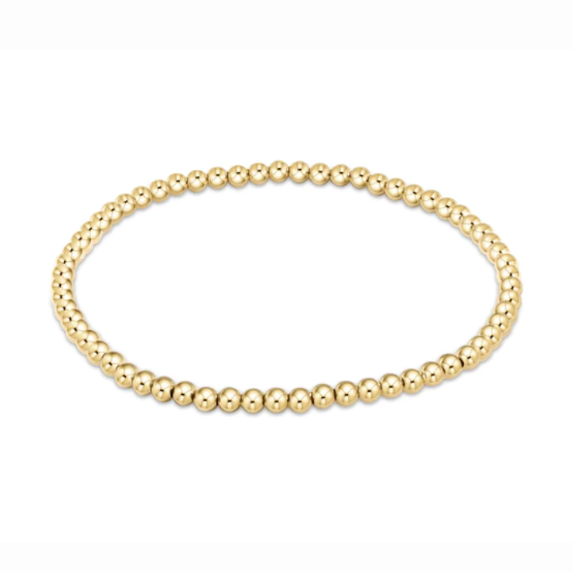 A delicate gold beaded bracelet featuring small, shiny, uniform beads arranged in a single strand on a plain white background