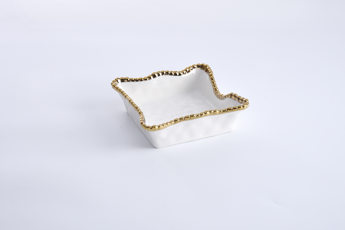 Ceramic square decorative dish on a white background featuring an irregular wavy rim and a metallic gold beaded edge with a glossy white finish
